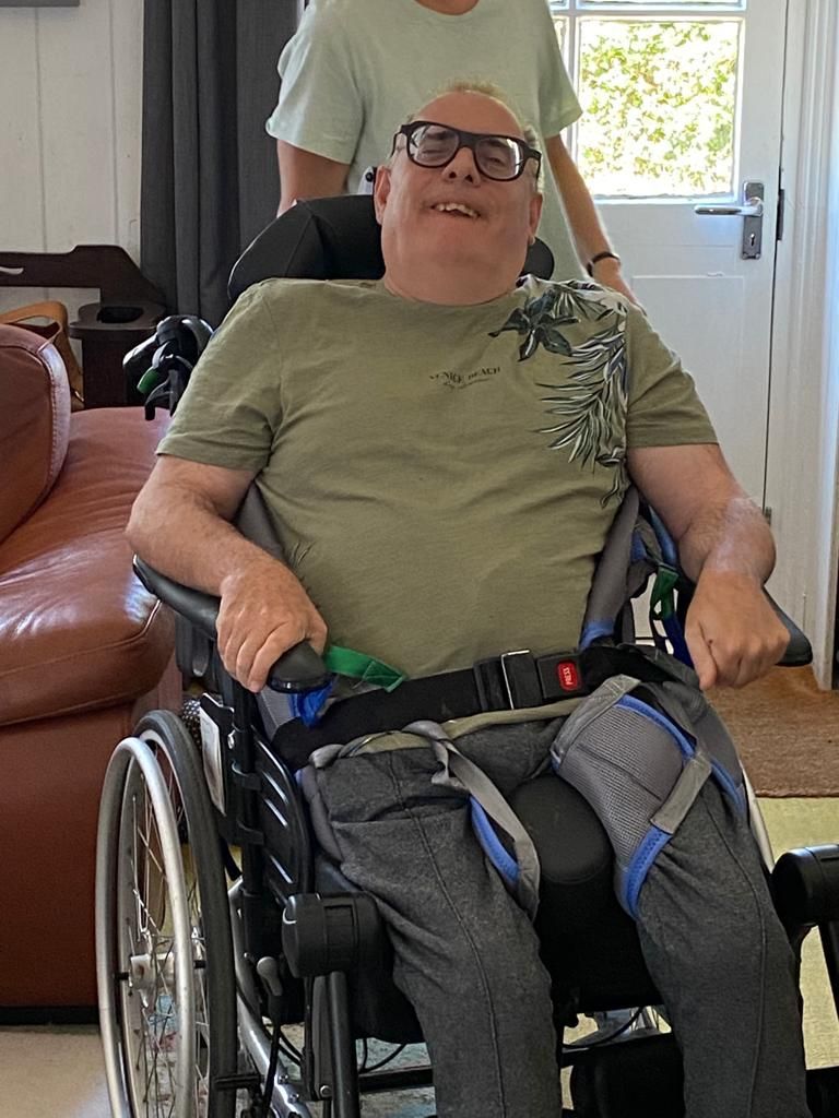 Daniel Anderson smiling in his wheelchair at home