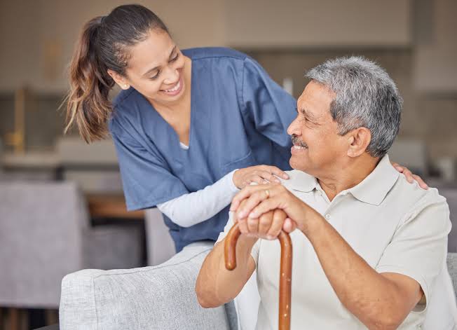 A compassionate SafiriCare caregiver supporting an elderly gentleman